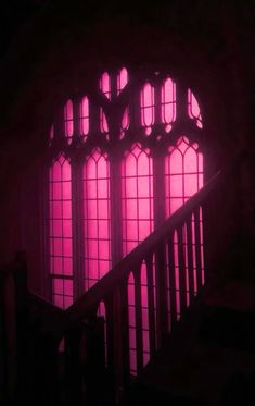 the stairs are lit up with bright pink light from windows in an old building that has been converted into a dark room