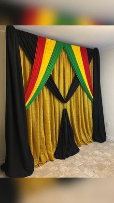 a curtain with black, yellow and red drapes on it in a living room