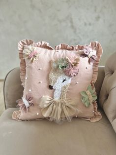 a decorative pillow on a chair with flowers in the center and a giraffe wearing a tutu skirt