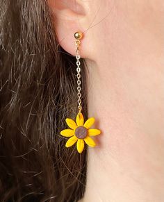 a close up of a person's ear wearing earrings with a flower on it