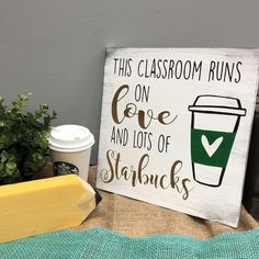 a sign that says this classroom runs on love and lots of starbuckss next to a cup of coffee