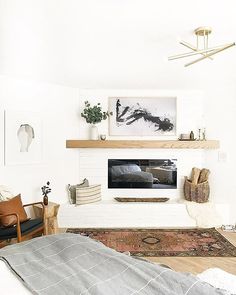 a living room filled with furniture and a flat screen tv mounted on a wall above a fire place