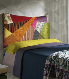 a bed with colorful sheets and pillows on it