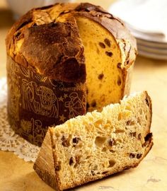 a loaf of bread sitting on top of a doily next to a slice of cake