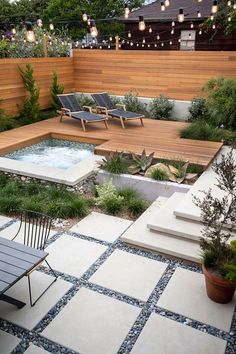 an outdoor hot tub in the middle of a patio with chairs and lights on it