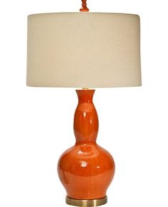 an orange table lamp with a white shade