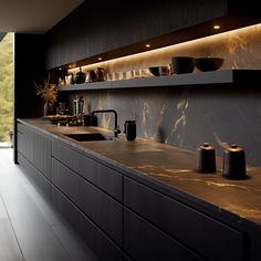 a kitchen with black cabinets and marble counter tops