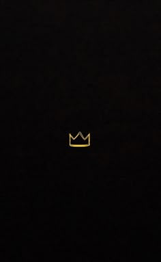 a black background with a yellow crown in the middle and one light shining on it