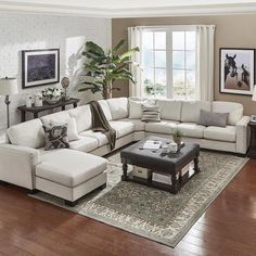 a living room filled with furniture and a large rug on top of a hard wood floor