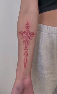 a person with a cross tattoo on their arm