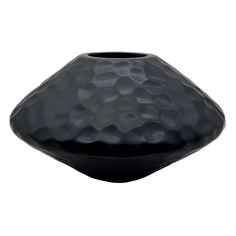 a black vase sitting on top of a white table