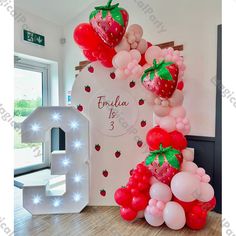 the balloon arch is decorated with strawberrys and balloons for an elegant birthday party or celebration