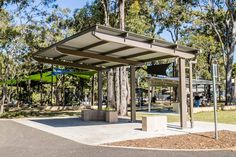 an empty park with trees and benches in the background