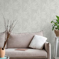 a living room with a couch, table and potted plants on the side tables