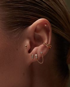 a woman wearing three different ear piercings