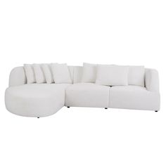 a white sectional sofa with pillows on it's back and side facing the couch