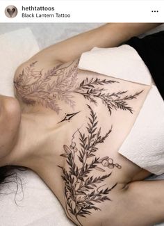 a woman laying on top of a bed with tattoos on her stomach and back side