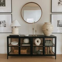 there is a mirror on the wall next to a shelf with vases and other items