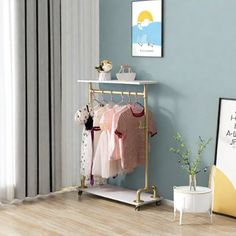 a baby's clothing rack in the corner of a room