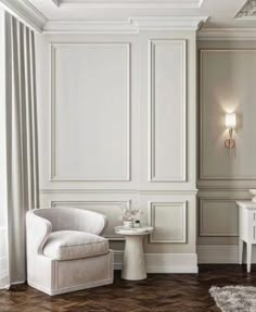 a white chair sitting next to a table on top of a hard wood floor in a room