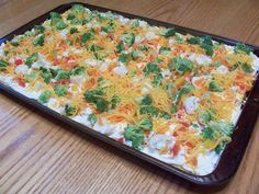 a casserole dish with broccoli, cheese and other toppings on it