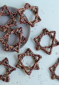 chocolate pretzels on a plate with sprinkles and sugar scattered around them