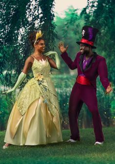 a man and woman dressed up as disney characters dancing in the grass with trees behind them