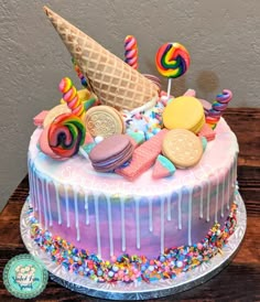 an ice cream cake decorated with candy, candies and lollipops on a wooden table