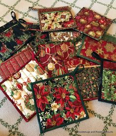 a pile of christmas themed placemats sitting on top of a white cloth covered table