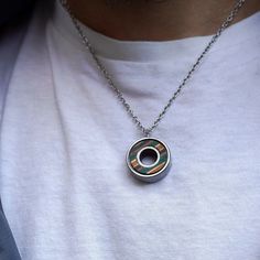 a man wearing a necklace with a circular design on it