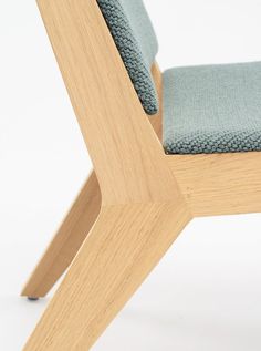 a wooden chair with a blue cushion on the back and armrests is shown