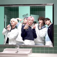 group of young men standing in front of a bathroom mirror