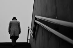 a man walking up some stairs with his coat on