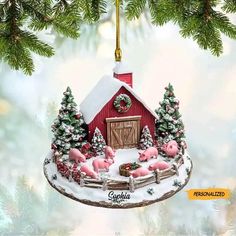 a christmas ornament with pigs on a sleigh in front of a barn