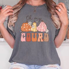 a woman wearing an oh my gourd t - shirt with pumpkins on it