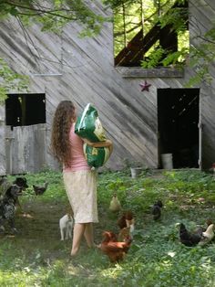 a woman holding a green bag in front of chickens