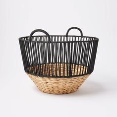 a woven basket with two handles on the bottom and one handle in the middle, against a white background