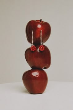 three apples stacked on top of each other in the shape of an apple with red beads