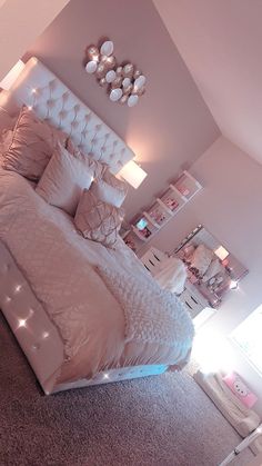 a large bed sitting in a bedroom next to a wall with lights on top of it