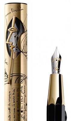 a fountain pen with writing on it next to a gold and black ink roller bottle