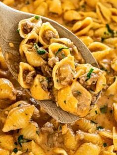 a wooden spoon filled with pasta and meat