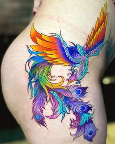 a colorful bird tattoo on the side of a woman's thigh, with multicolored feathers