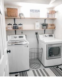 a washer and dryer sitting in a room next to each other with shelves above them