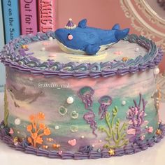 there is a cake decorated with an ocean theme and fish on it's side