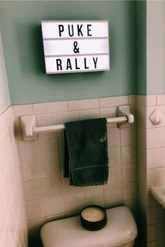 there is a toilet and sink in the bathroom with a sign above it that says puke & rallyy