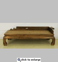 an old wooden tray sitting on top of a floor next to a white wall with the words click to enlarge above it