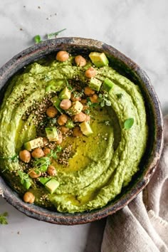 a bowl filled with guacamole and garnished with chickpeas