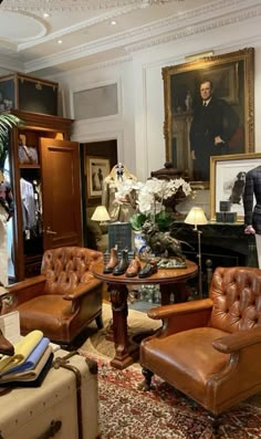 a living room filled with lots of furniture next to a painting on the wall above a fireplace