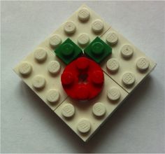 a red and green object made out of legos on a white surface with one piece missing