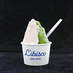 a scoop of ice cream in a white cup with a blue lid and the word libiasco gelato on it